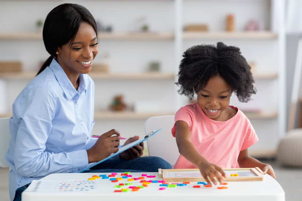 Smiling,Child,Development,Specialist,Young,African,American,Woman,Esting,Cute